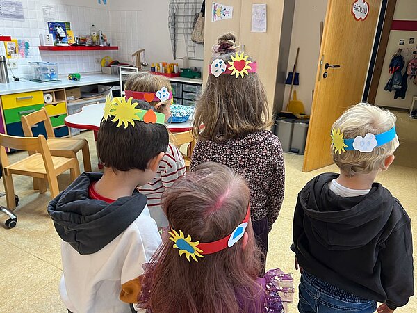 Kinder mit gebastelten Kränzen