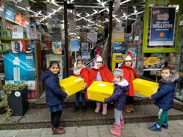 Kinder bringen Pakete zur Poststelle 