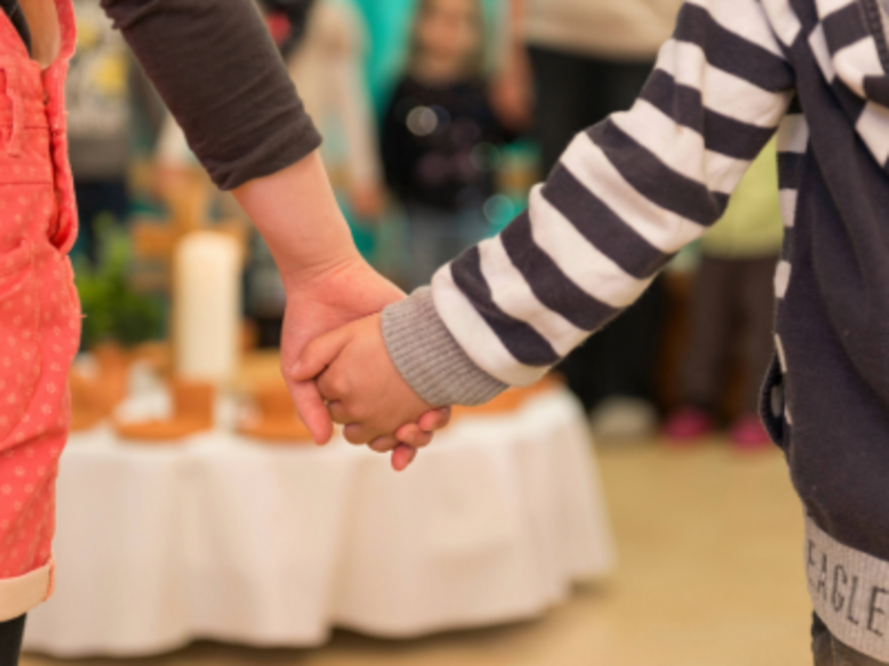 Zwei Kinder halten sich an den Händen