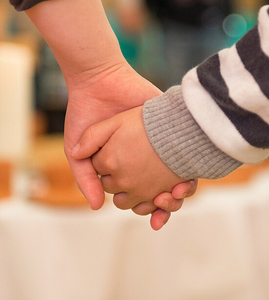 Zwei Kinder halten sich an den Händen
