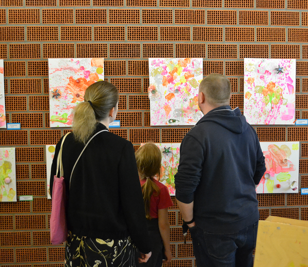 Familien betrachten Kunst der Kinder