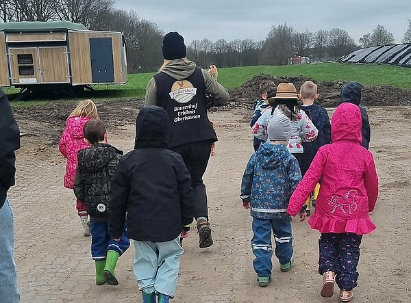 Kinder laufen &uuml;ber Bauernhofgel&auml;nde