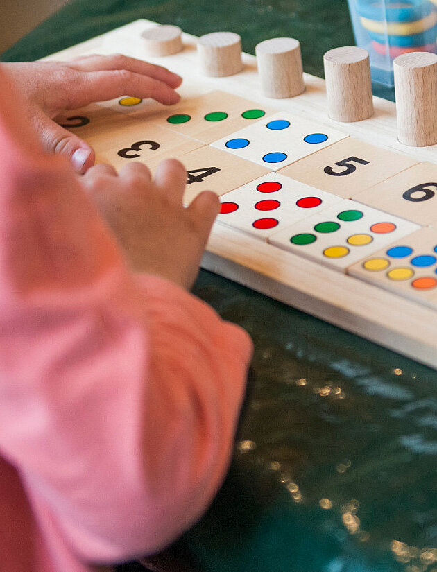 Kind spielt mit Zahlenpuzzle