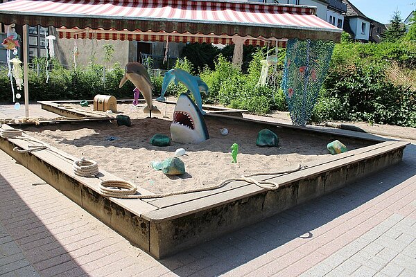 Hai- und Delfin-Spielfiguren im Sandkasten