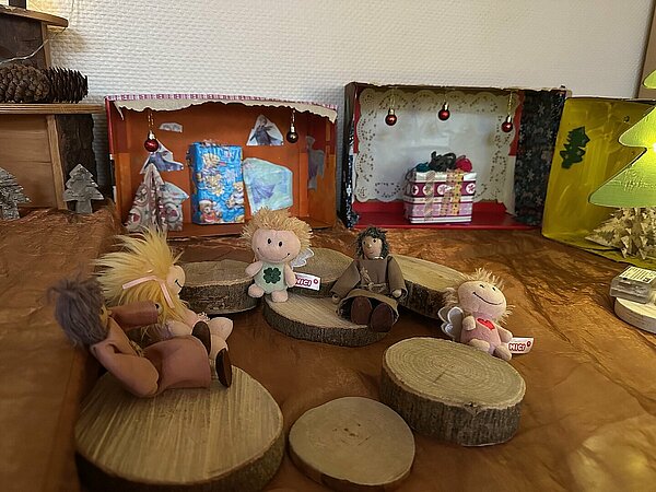 Spielfiguren sitzen im Adventsmarkt