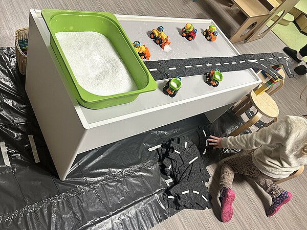 Tisch mit Stra&szlig;enlandschaft und Spielzeug