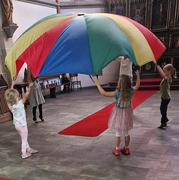 Kinder spielen mit Schwungtuch