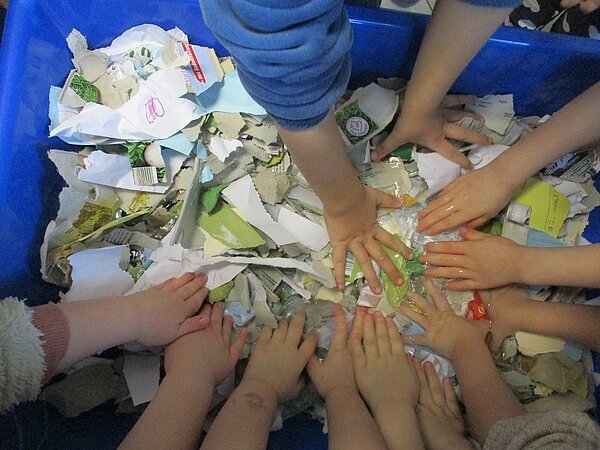 Kinder weichen Papier in Wasser ein
