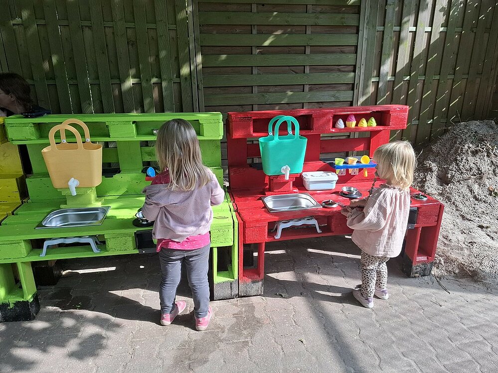 Kinder stehen an Matschküche 