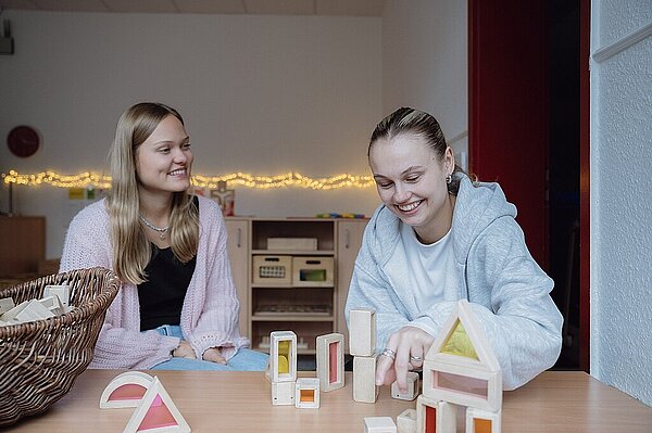 Zwei Mitarbeiterinnen sitzen vor Baumaterial im Konstruktionsbereich