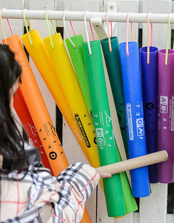 Kind muziziert mit Hölzern auf Klangrohren