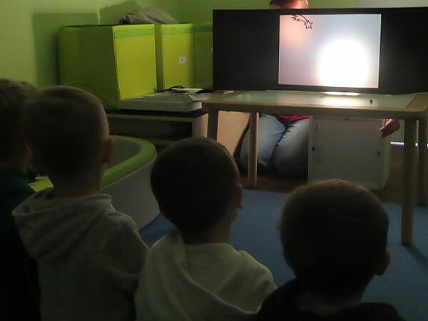 Kinder schauen dem Schattentheater zu