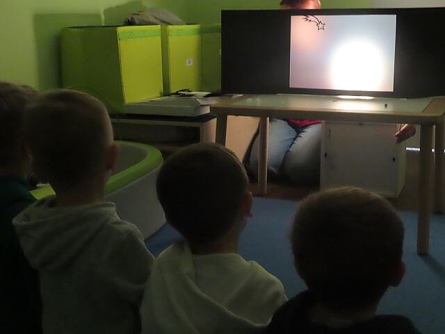 Kinder schauen dem Schattentheater zu