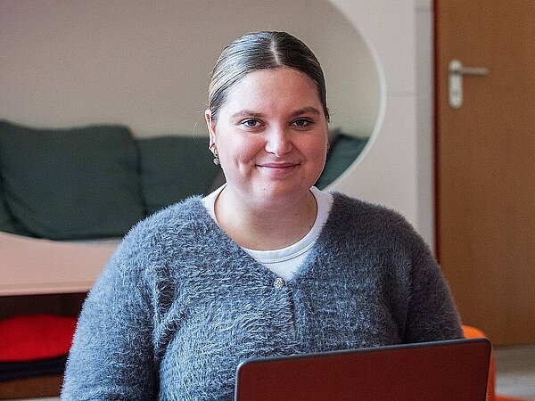 Mitarbeiterin sitzt am Laptop in der KiTa