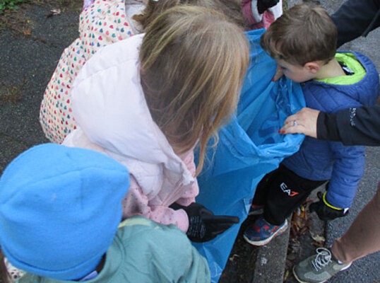 Kinder schauen in einen Müllsack