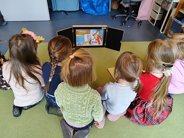 Kinder betrachten Kamishibai-Erzähltheater
