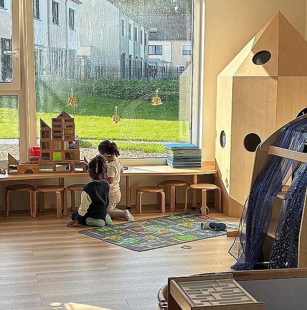 Kinder spielen an der Fensterbank