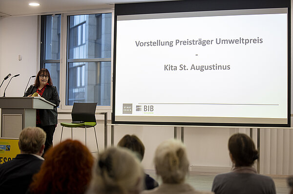 KiTa-Leiterin Birgit Dunschen präsentiert ihr Umweltpreis auf Bühne