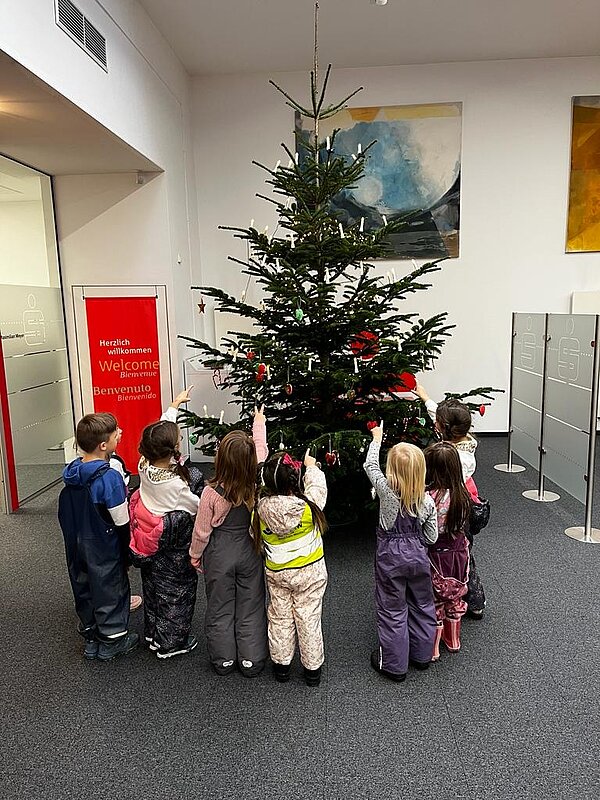 Kinder schmücken Weihnachtsbaum