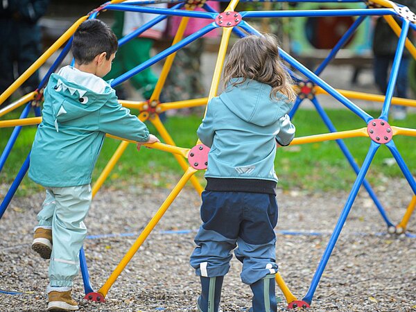 Kinder spielen auf Klettergerüst