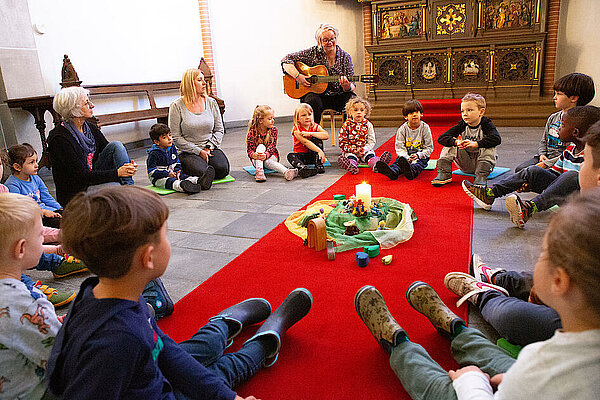 Kinder sitzen in Kirche im Kreis auf dem Boden