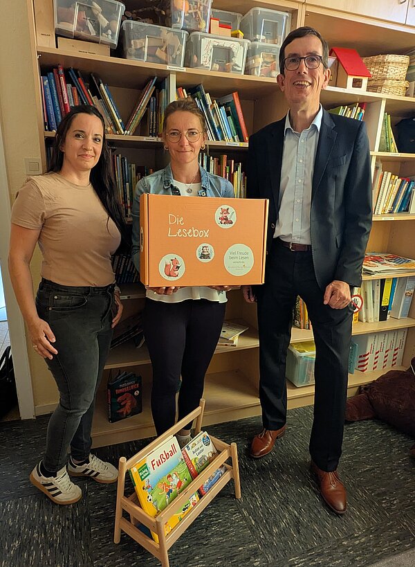 3 Personen zeigen Lesebox in die Kamera
