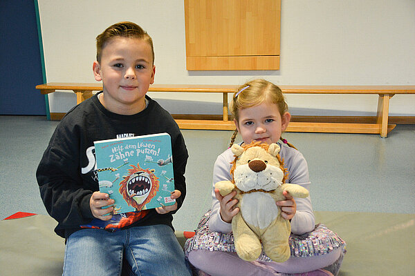Kinder zeigen Kinderbuch in Kamera