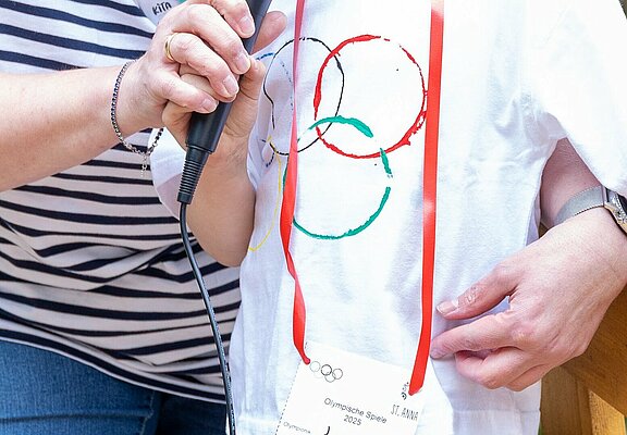 Kind trägt Olympia-Tshirt und eröffnet die Spiele