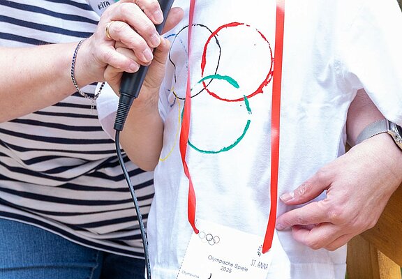 Kind trägt Olympia-Tshirt und eröffnet die Spiele