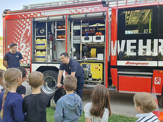 Kinder stehen vor Feuerwehrauto