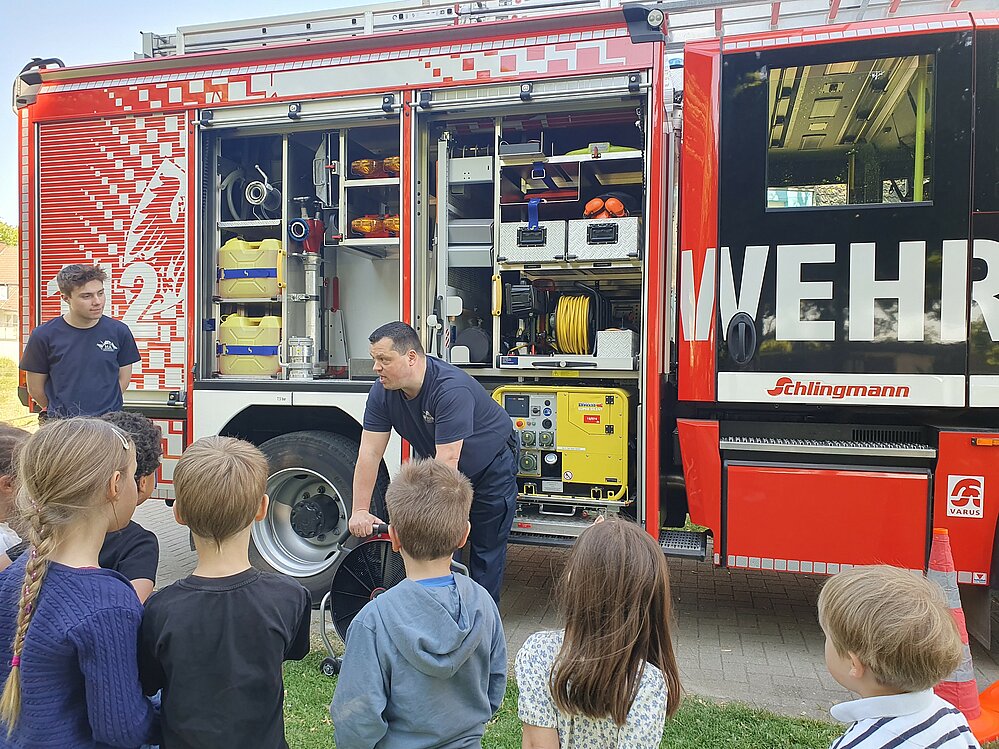 Kinder stehen vor Feuerwehrauto