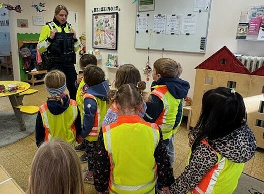 Kinder hören der Polizistin zu
