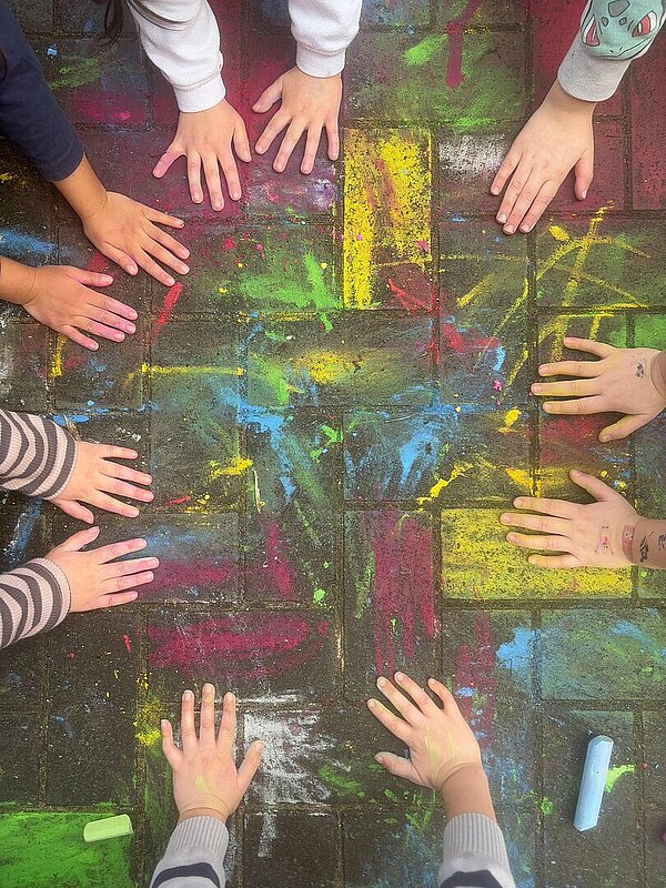 Buntes Kreidebild mit Kinderhänden