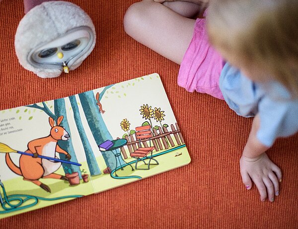 Kind liest ein Buch mithilfe der Leseeule LUKA