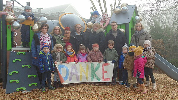 Gruppenfoto Stadtwerke Bochum und KiTa Zweckverband, Kinder und Teilnehmende stehen vor Kletteranlage