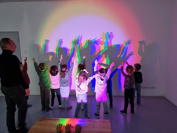 Kinder spielen mit Licht und Schatten