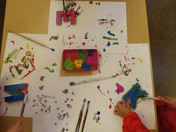 Tisch mit bunte bemalten Holzbuchstaben