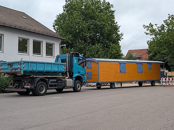 LKW liefert Bauwagen