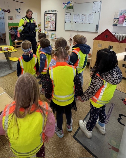 Kinder hören der Polizistin zu