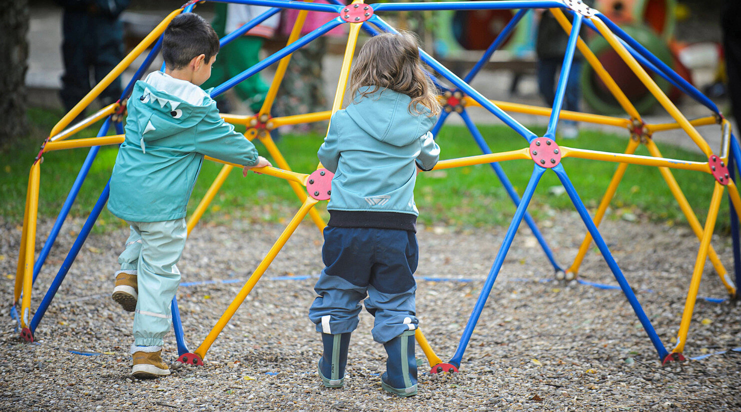 Kinder spielen an einem Klettergerüst
